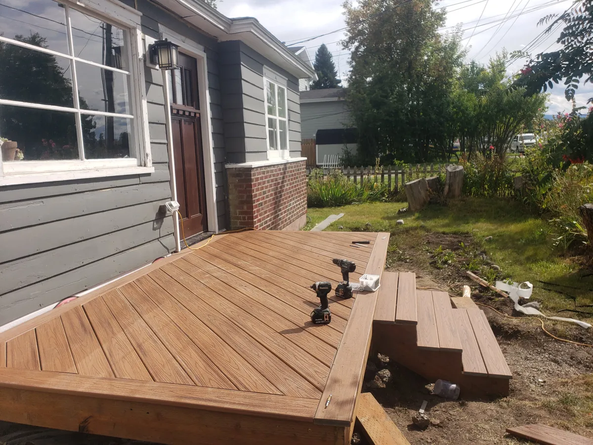 Deck foundation and framing work at log cabin structure