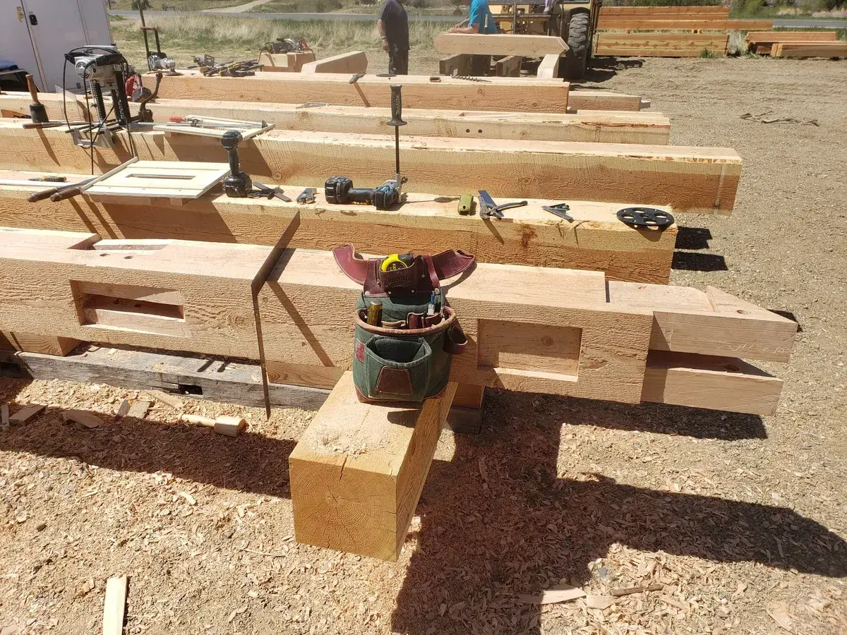 Timber frame construction progress with multiple bents raised and connected