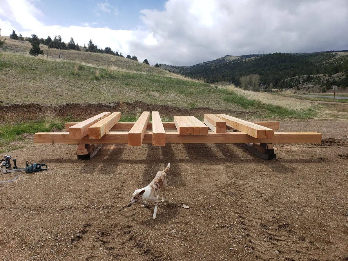 Timber frame raising with crew lifting heavy bent into position